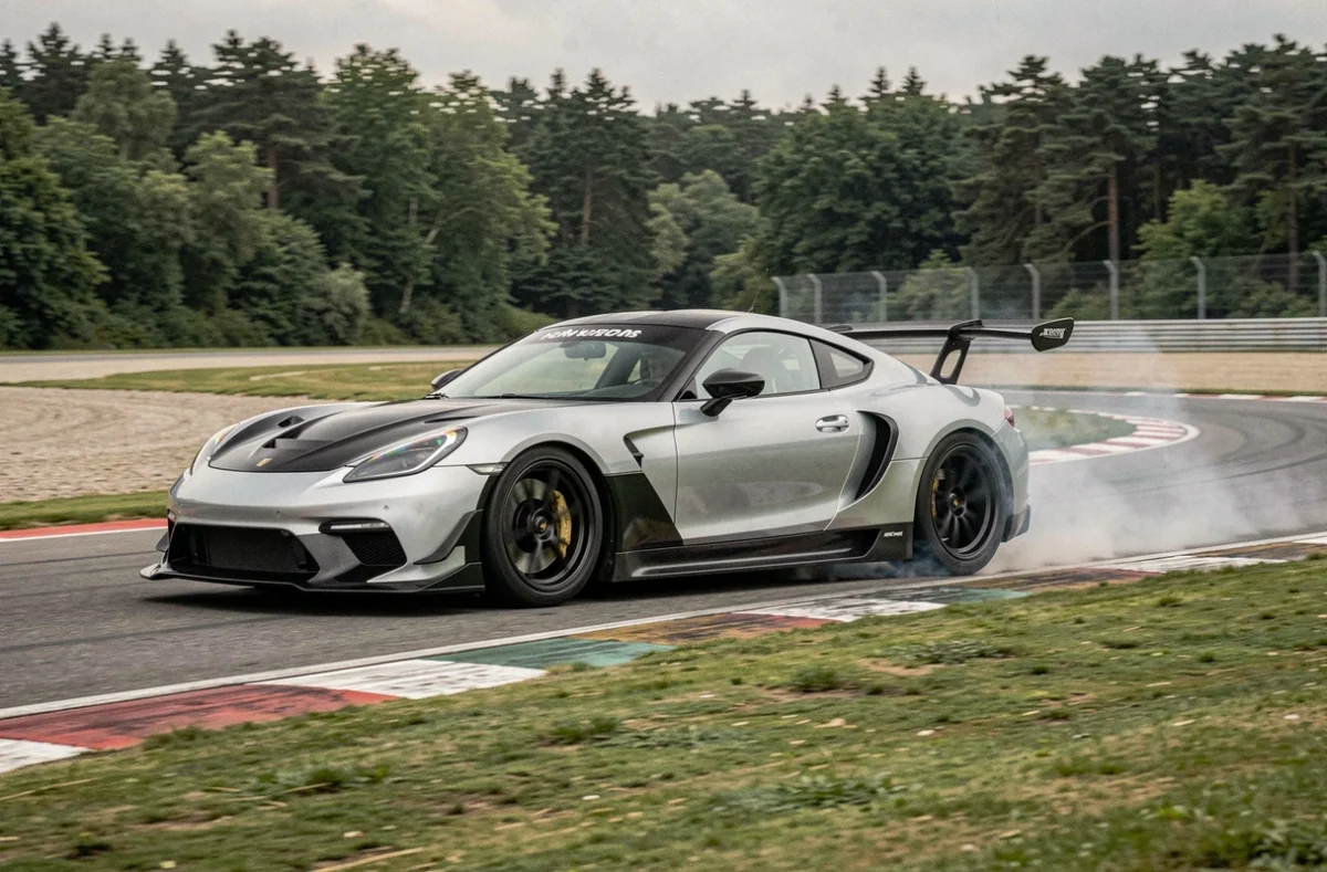 Voiture GT argent et noire en plein virage sur un circuit de course, avec flou de filé et fumée légère des pneus